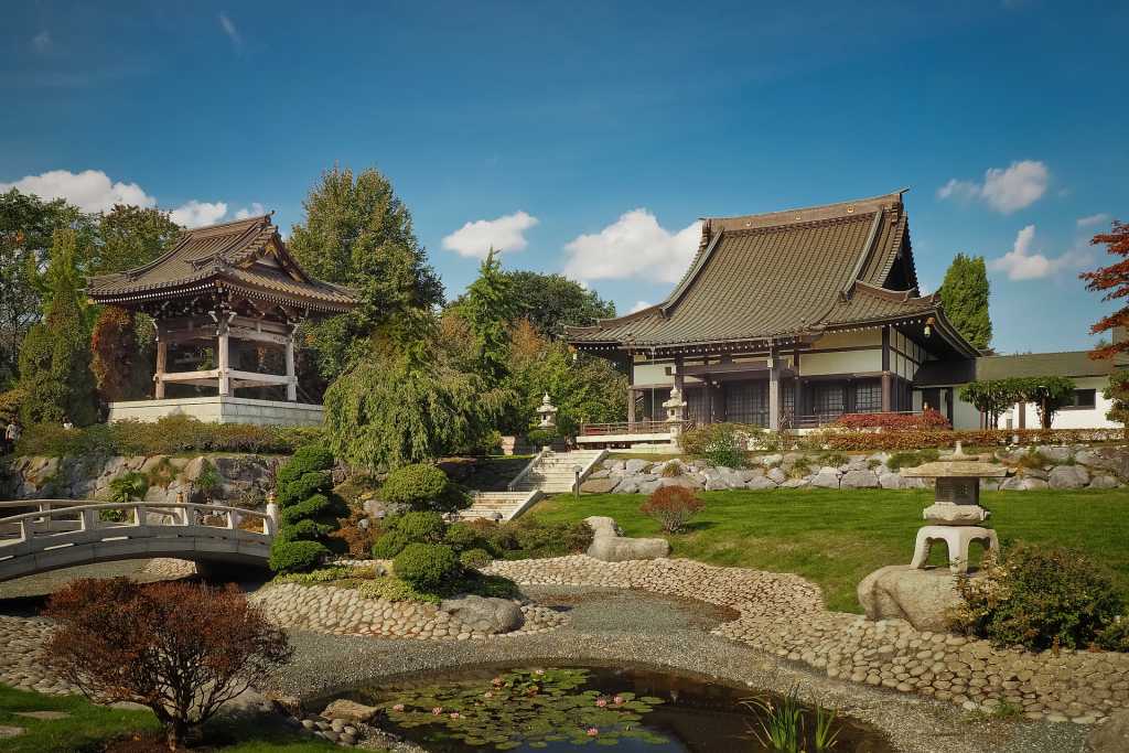japanese zen garden with with temple, water features, grass and temples